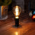 Illuminate with Timeless Charm: Edy A100's LED Filament Offers Brightness & Durability, Mimicking Smoked Glass Elegance.
